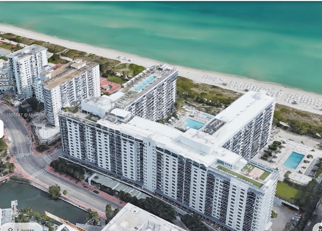 birds eye view of property with a beach view and a water view