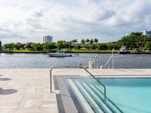 view of swimming pool featuring a water view