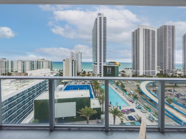 balcony with a water view and a community pool