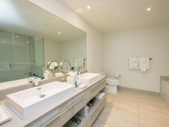 bathroom featuring tile flooring, toilet, vanity with extensive cabinet space, and dual sinks