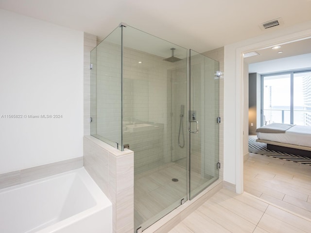 bathroom featuring shower with separate bathtub and tile flooring