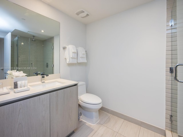 bathroom featuring tile flooring, toilet, vanity, and walk in shower