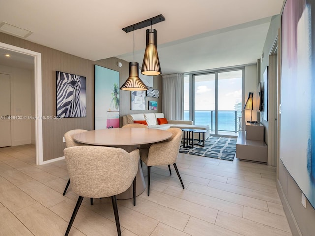 dining area featuring floor to ceiling windows and a water view