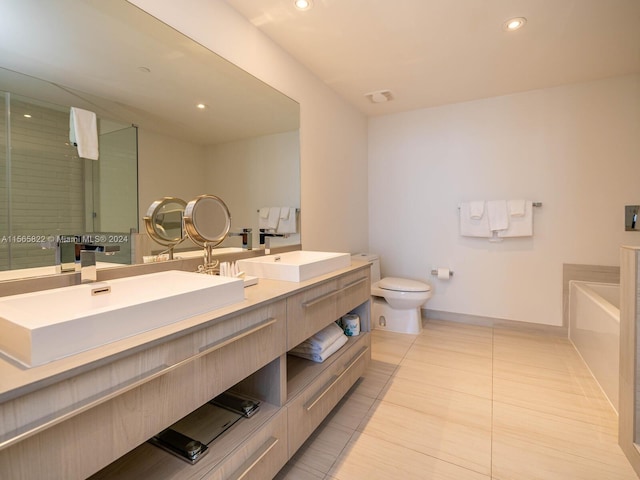 bathroom featuring tile flooring, toilet, a bathtub, and dual bowl vanity