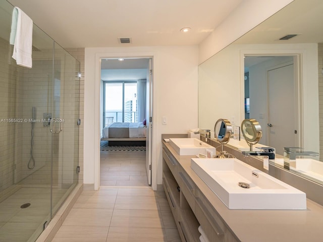 bathroom with dual bowl vanity, tile floors, and an enclosed shower