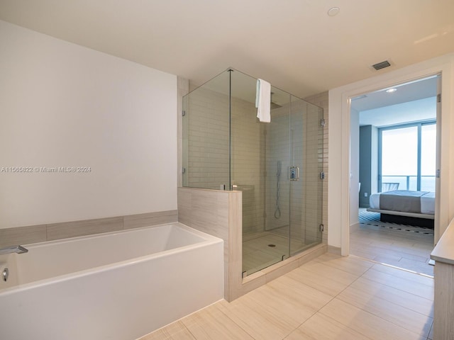 bathroom featuring tile flooring and independent shower and bath