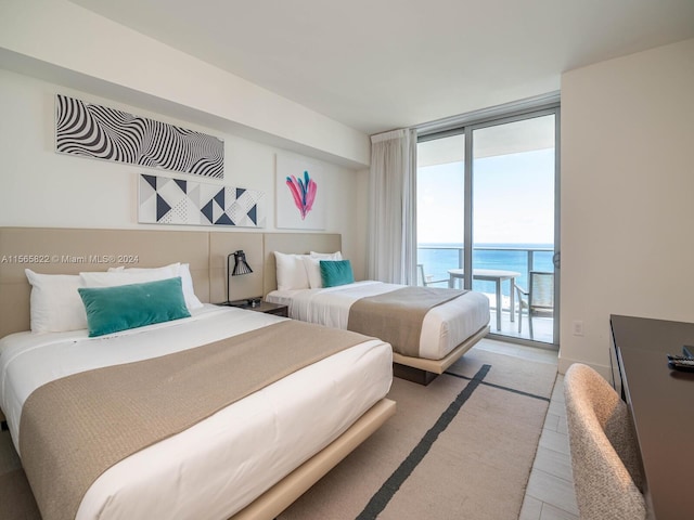 bedroom featuring a water view, floor to ceiling windows, and access to outside