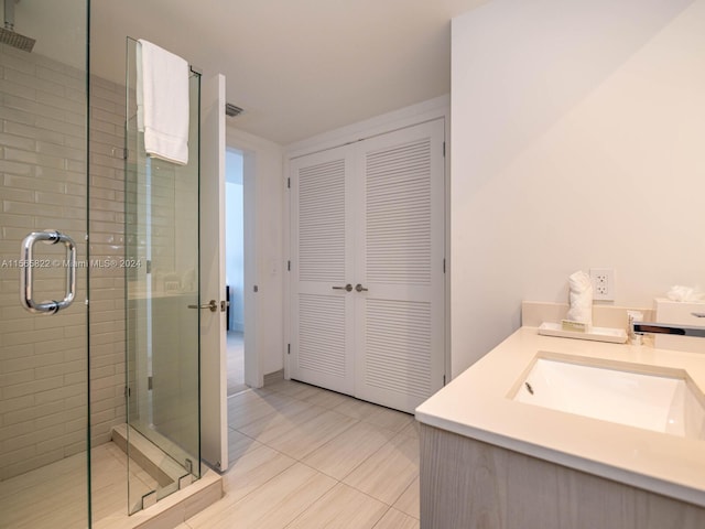 bathroom featuring tile flooring, vanity, and an enclosed shower