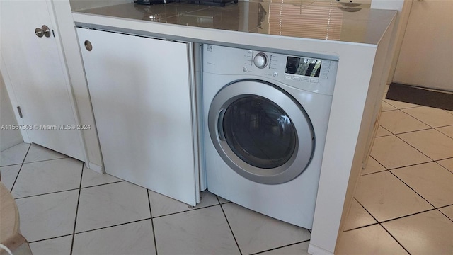 laundry area featuring laundry area, washer / clothes dryer, and light tile patterned floors