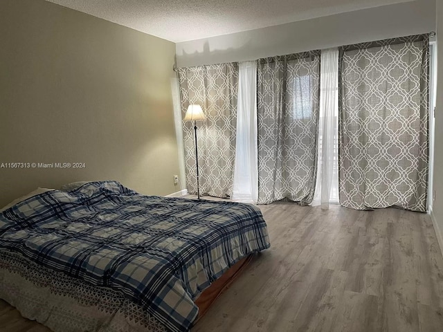 bedroom featuring a textured ceiling and hardwood / wood-style flooring