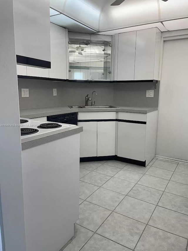 kitchen with sink, white cabinetry, and light tile floors