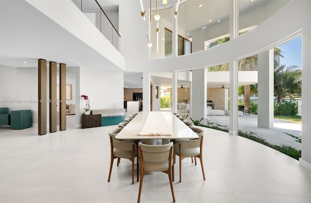 dining area with a healthy amount of sunlight, light tile floors, and a towering ceiling