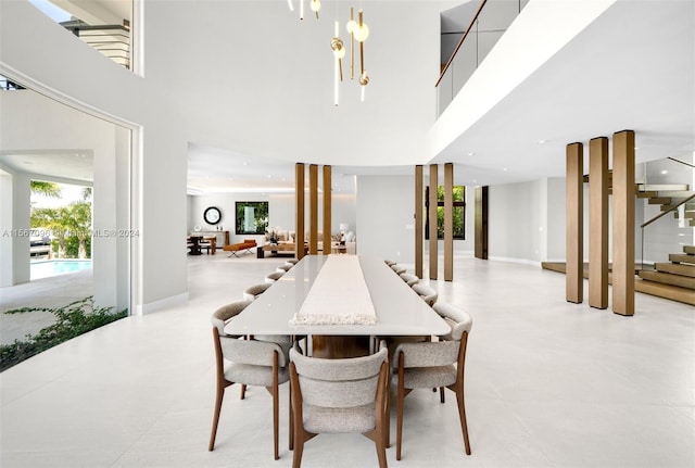 dining area featuring a chandelier, light tile floors, and a high ceiling