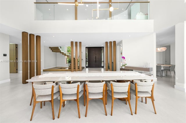 kitchen featuring decorative light fixtures and a towering ceiling