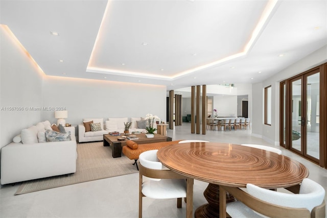 dining space featuring a raised ceiling and french doors