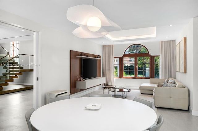 tiled dining area with a raised ceiling