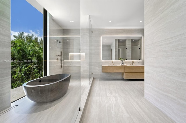 bathroom featuring tile walls, vanity, and plus walk in shower