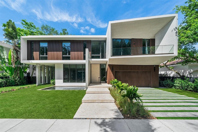 rear view of property featuring a lawn and a balcony