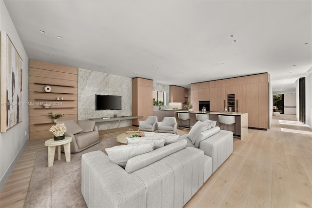 living room with light hardwood / wood-style flooring and wooden walls