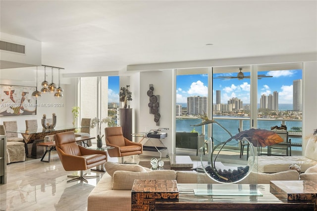 tiled living room with ceiling fan, a water view, and plenty of natural light