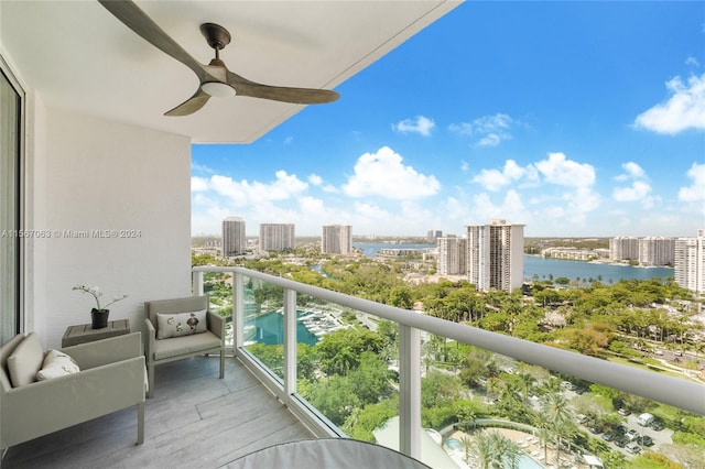 balcony with ceiling fan and a water view