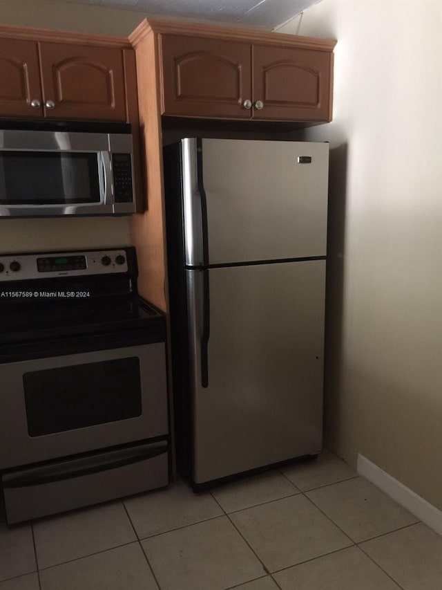 kitchen with appliances with stainless steel finishes and light tile floors