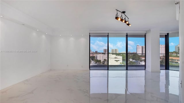 tiled spare room featuring a wall of windows