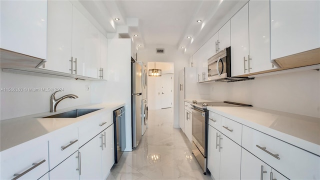 kitchen featuring sink, stainless steel appliances, light tile floors, and white cabinetry