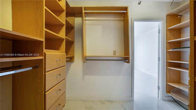 walk in closet featuring light tile floors