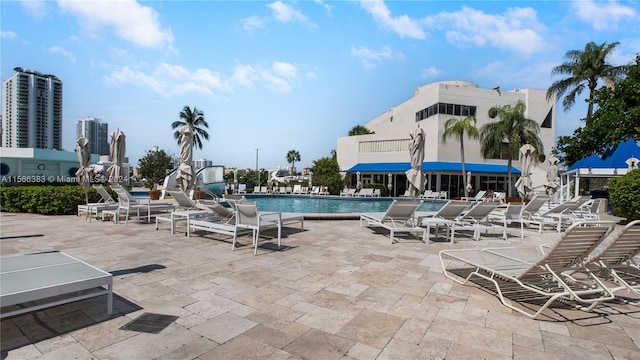 view of swimming pool with a patio and a water slide