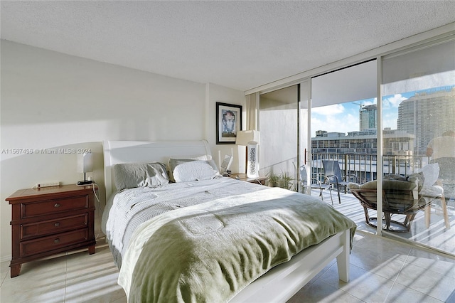 bedroom with expansive windows, access to exterior, and a textured ceiling