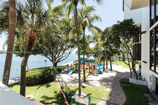 view of playground with a yard and a water view