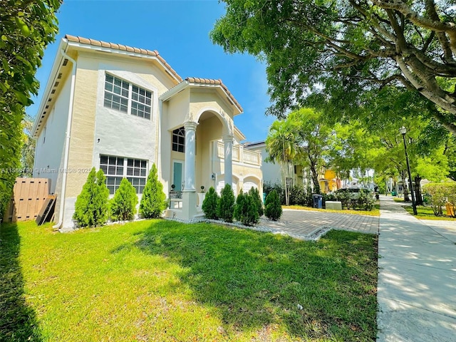 mediterranean / spanish home featuring a front lawn