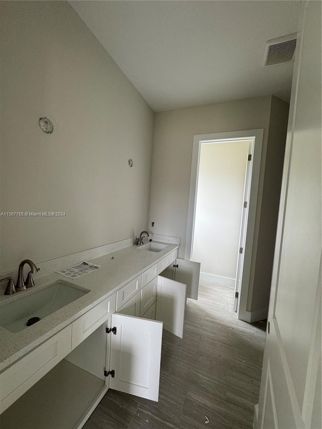 bathroom with vanity, hardwood / wood-style flooring, and a bathtub