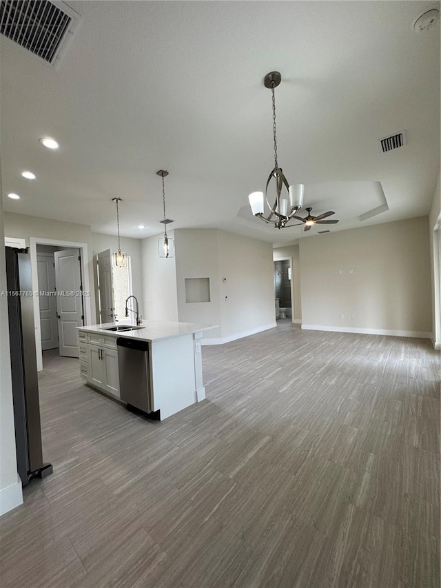 kitchen featuring appliances with stainless steel finishes, pendant lighting, an island with sink, sink, and white cabinets