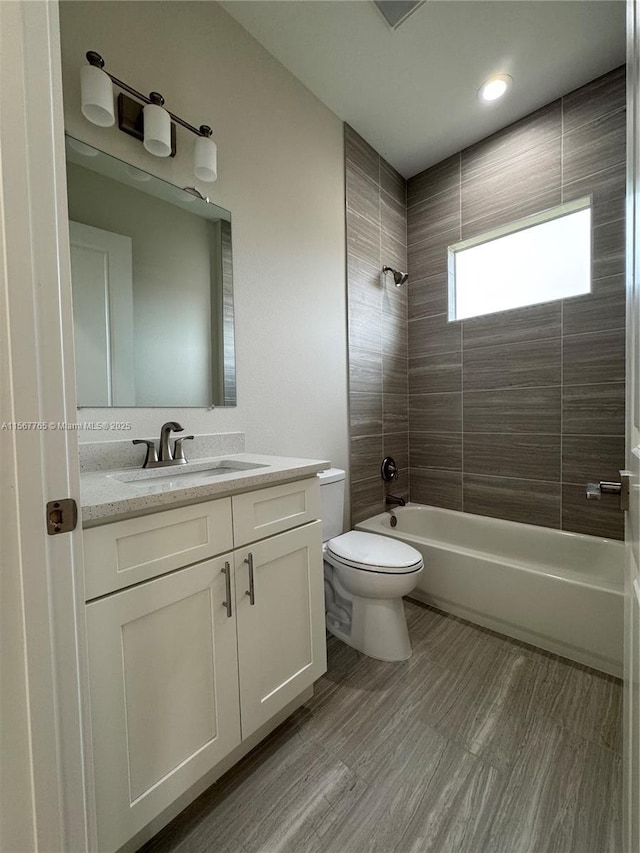 full bathroom with vanity, toilet, and tiled shower / bath