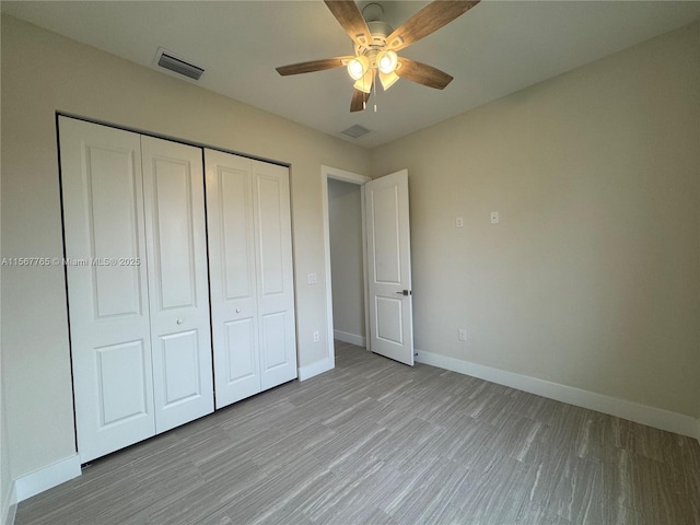 unfurnished bedroom with light hardwood / wood-style flooring, ceiling fan, and a closet