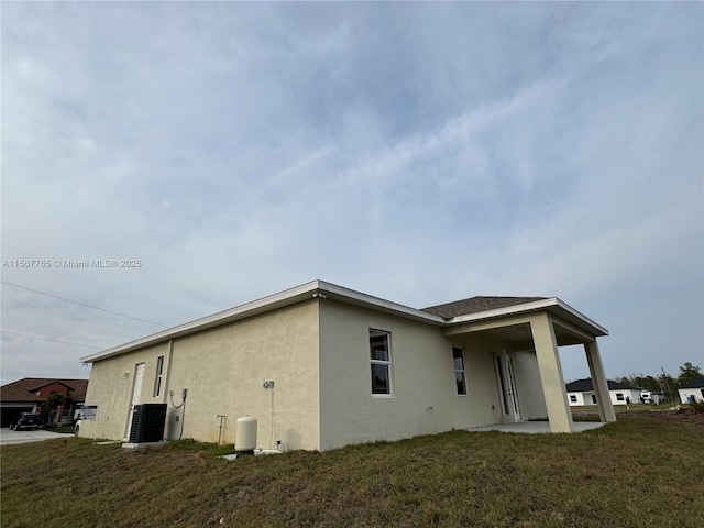 exterior space with central AC and a lawn