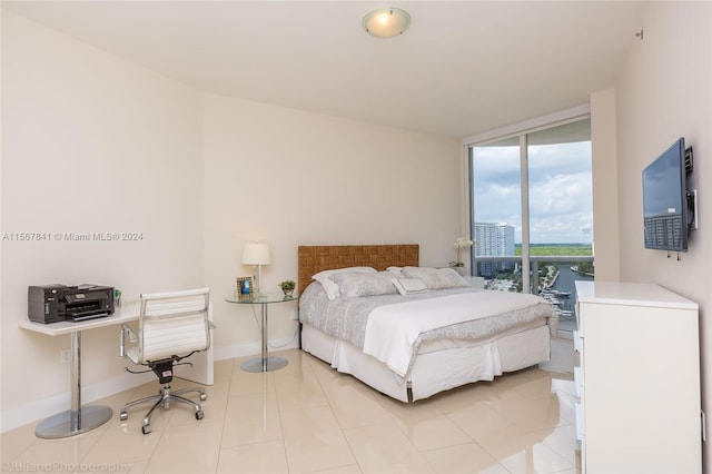 bedroom featuring light tile floors, access to exterior, and expansive windows