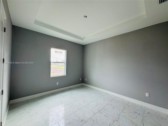 unfurnished room with a raised ceiling