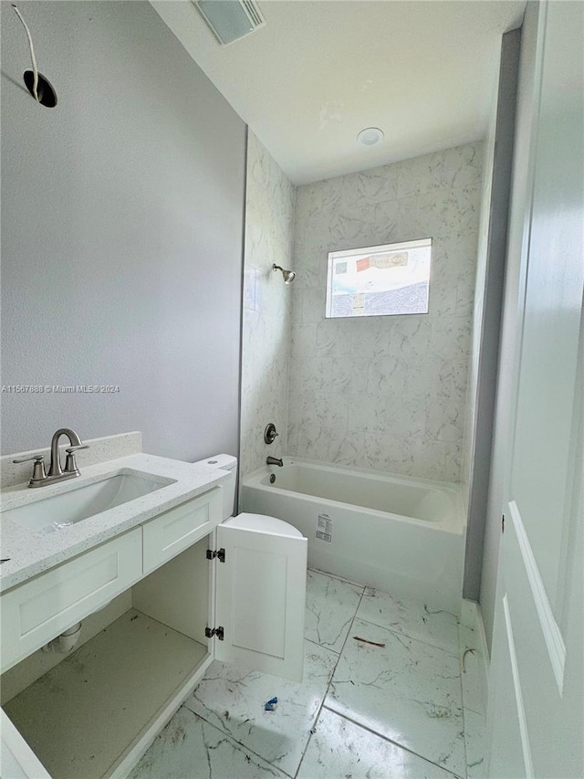 full bathroom featuring vanity, tiled shower / bath combo, and toilet