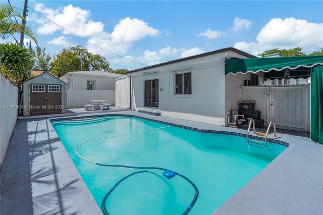 view of pool with a patio and a storage unit