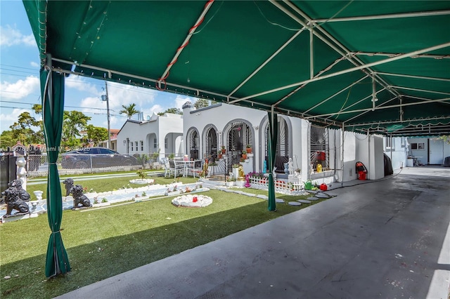 exterior space with a lawn, fence, and a carport