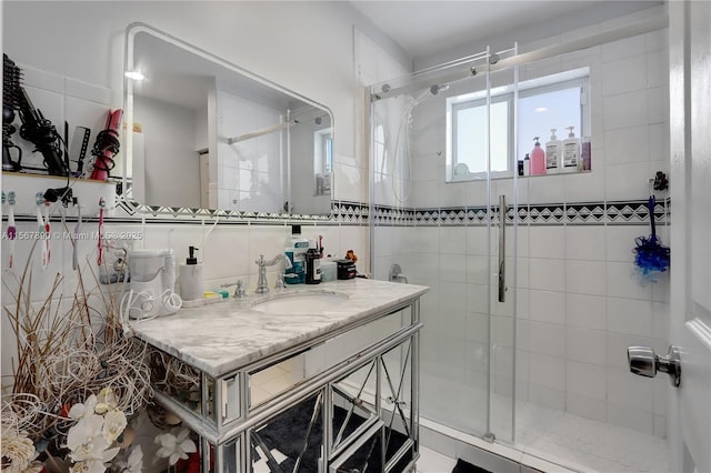 full bathroom featuring tile walls, backsplash, a shower stall, and vanity