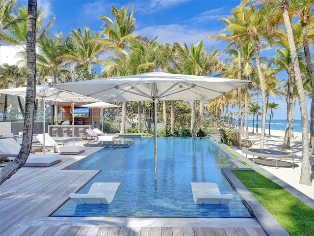 view of pool with a deck with water view