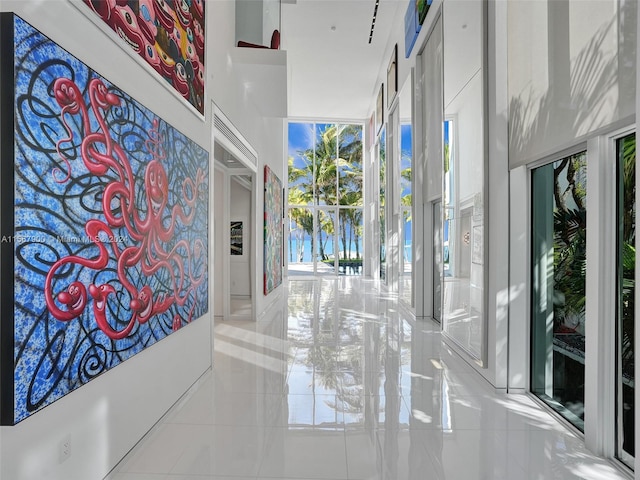 corridor featuring a high ceiling and light tile flooring