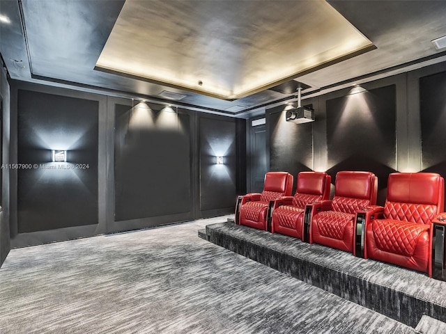 carpeted cinema featuring a raised ceiling