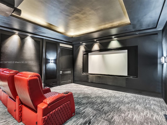 carpeted cinema with a raised ceiling