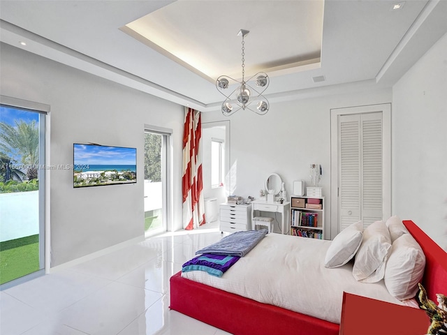 bedroom with a closet, light tile flooring, a raised ceiling, access to exterior, and a chandelier