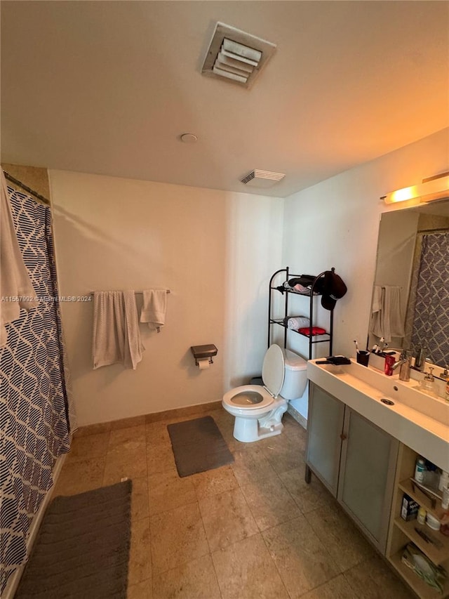 bathroom with tile flooring, toilet, and vanity